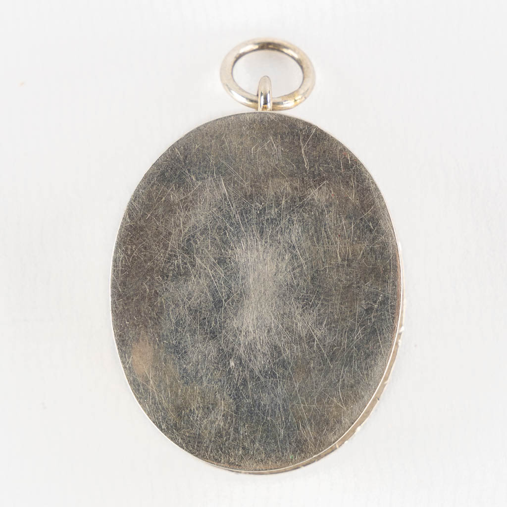 A silver pendant with a sealed theca 