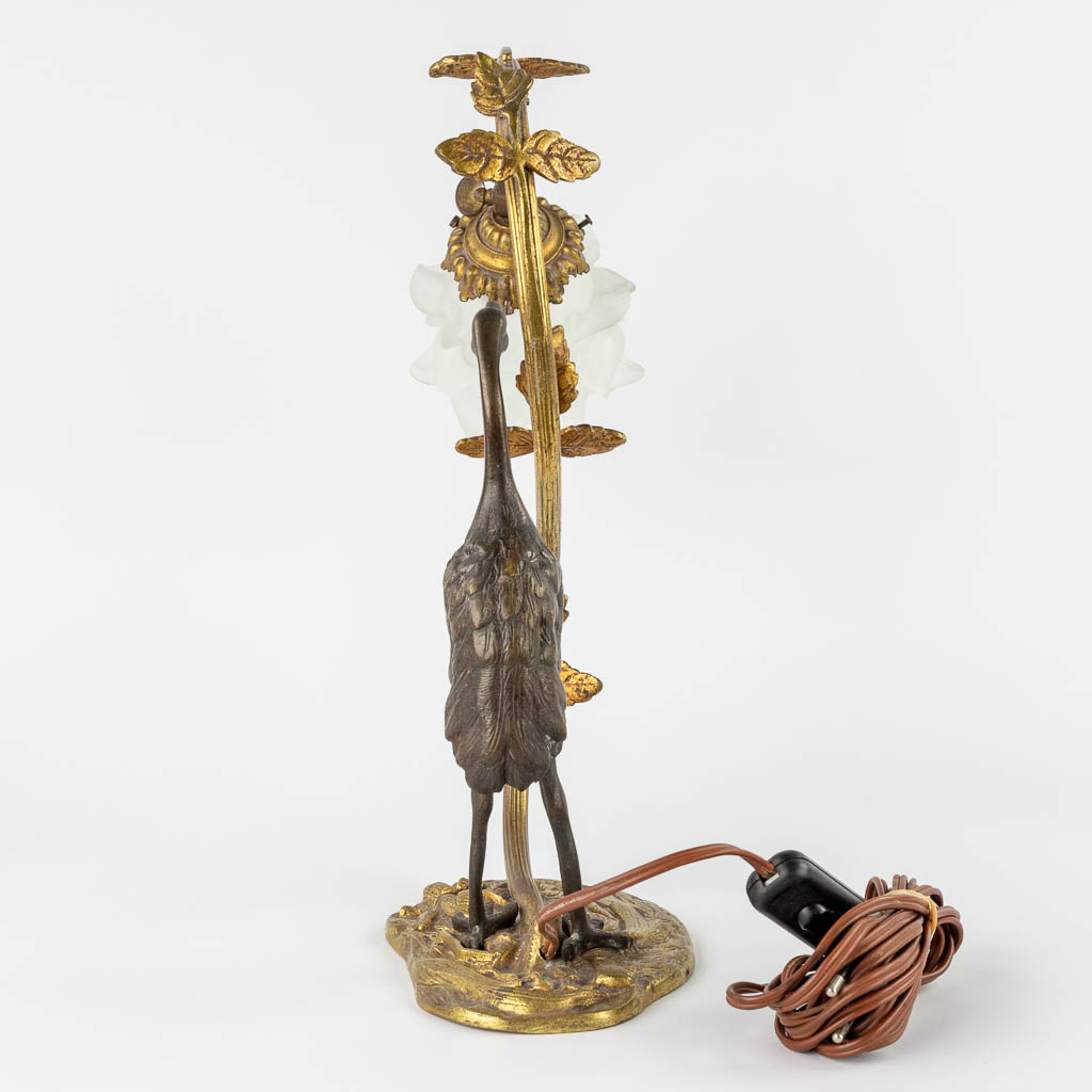 A table lamp with a large bird, probably a Heron. Patinated and gilt bronze, circa 1900. (W:33 x H:37 cm)