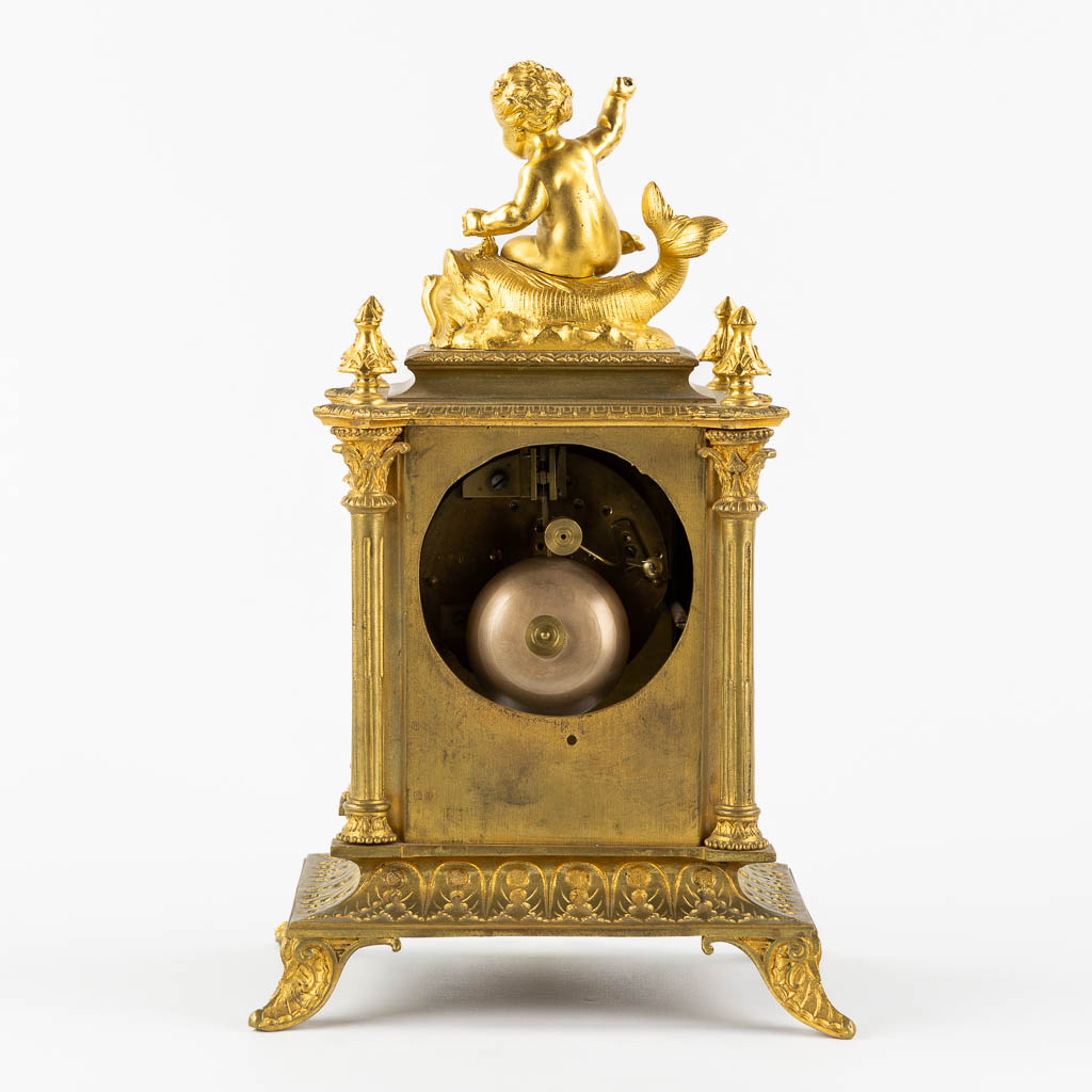 A mantle clock, gilt bronze mounted with porcelain. 19th C.