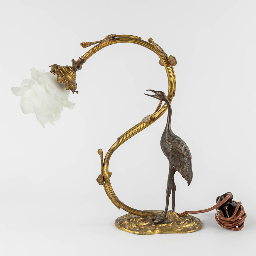 A table lamp with a large bird, probably a Heron. Patinated and gilt bronze, circa 1900. (W:33 x H:37 cm)