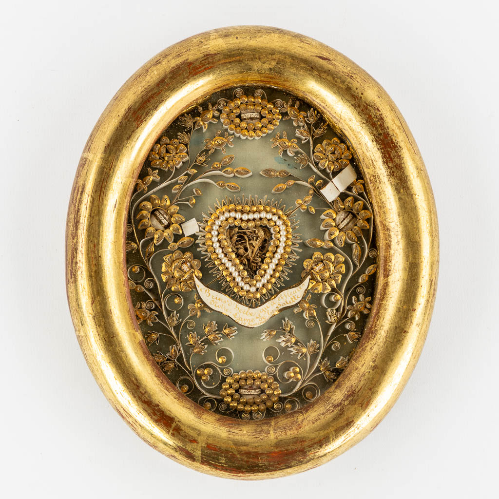 An oval reliquary frame, with relics for Popes, Saints, Virgins and Martyrs. 19th C.