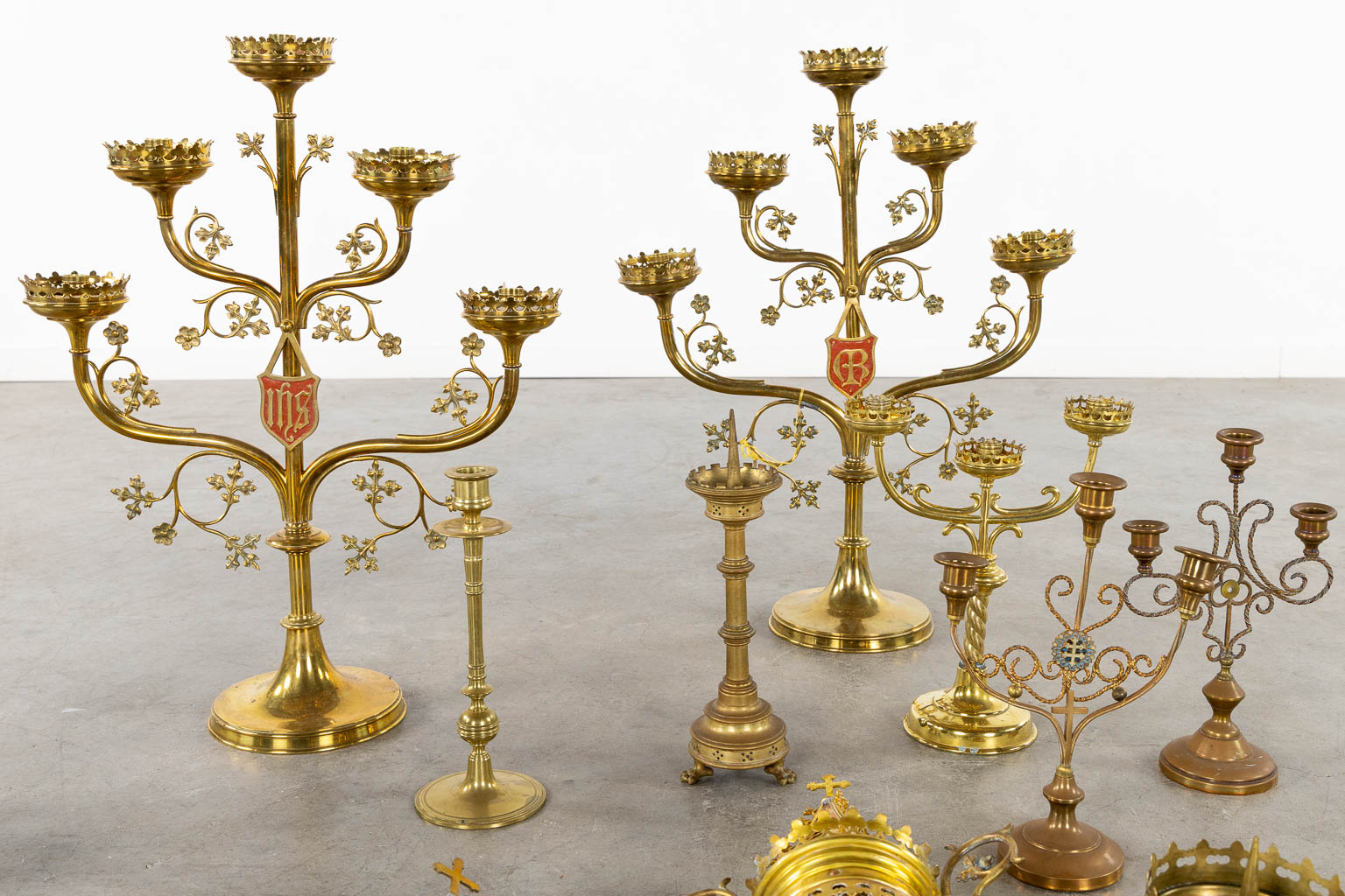 A large collection of church candelabra, lights and a crucifix, brass. (W:46 x H:61 cm)