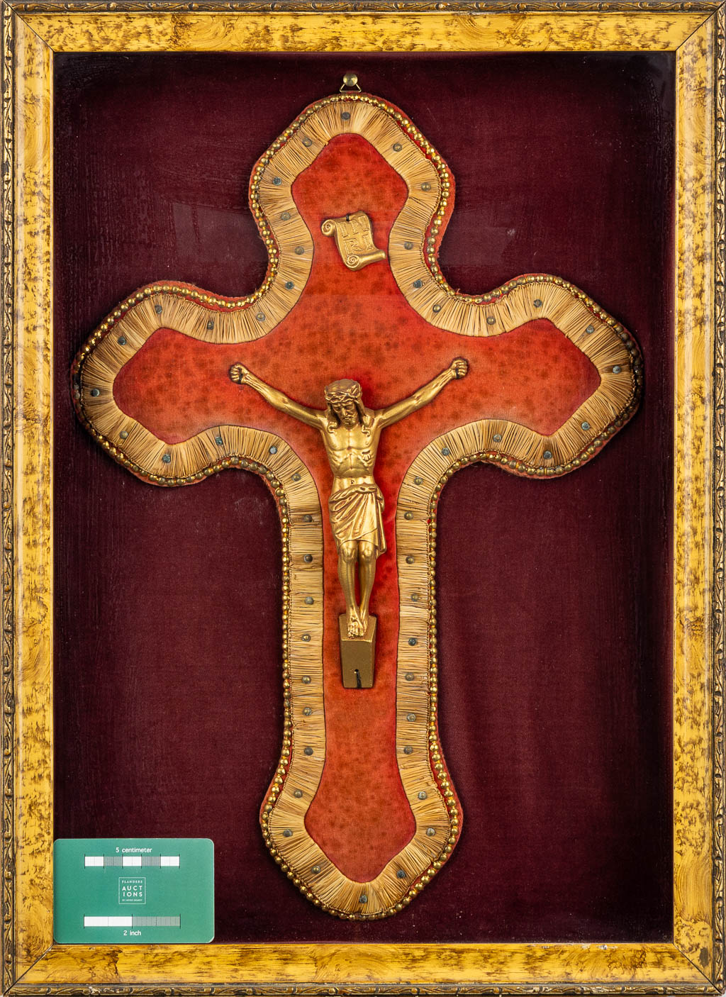 A framed embroidered crucifix with a Corpus Christi, framed behind glass. 