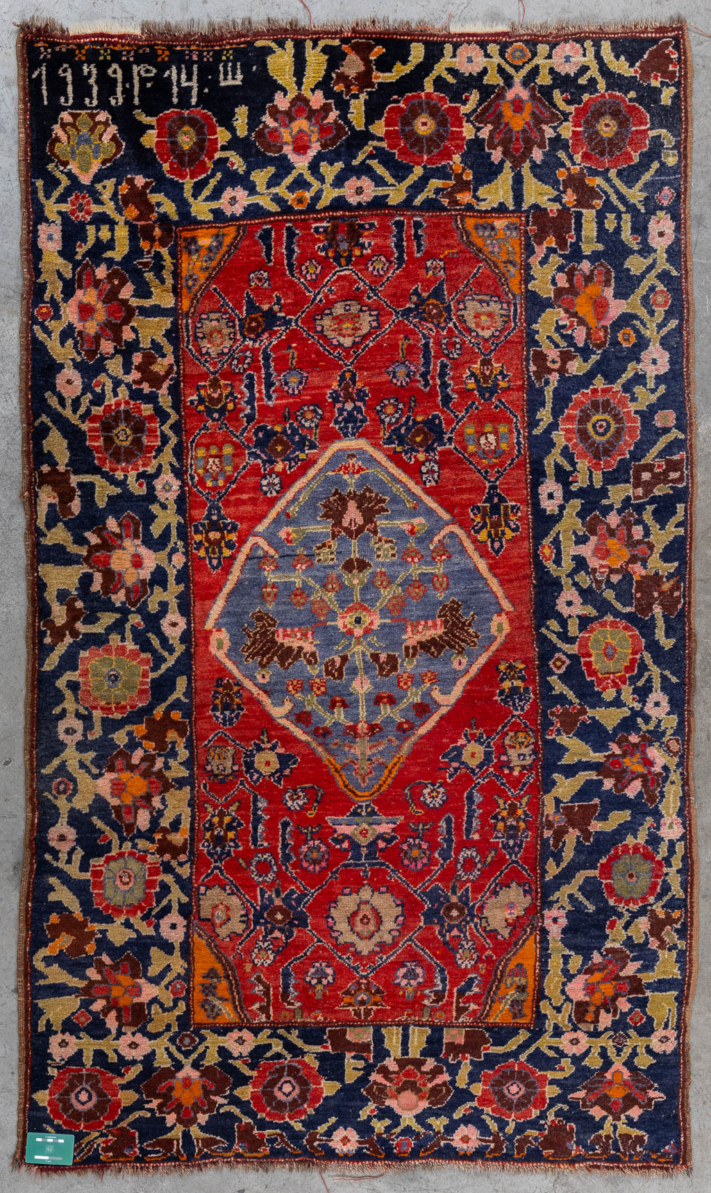 An Oriental hand-made carpet, dated 1939.. (W:124 x H:196 cm)