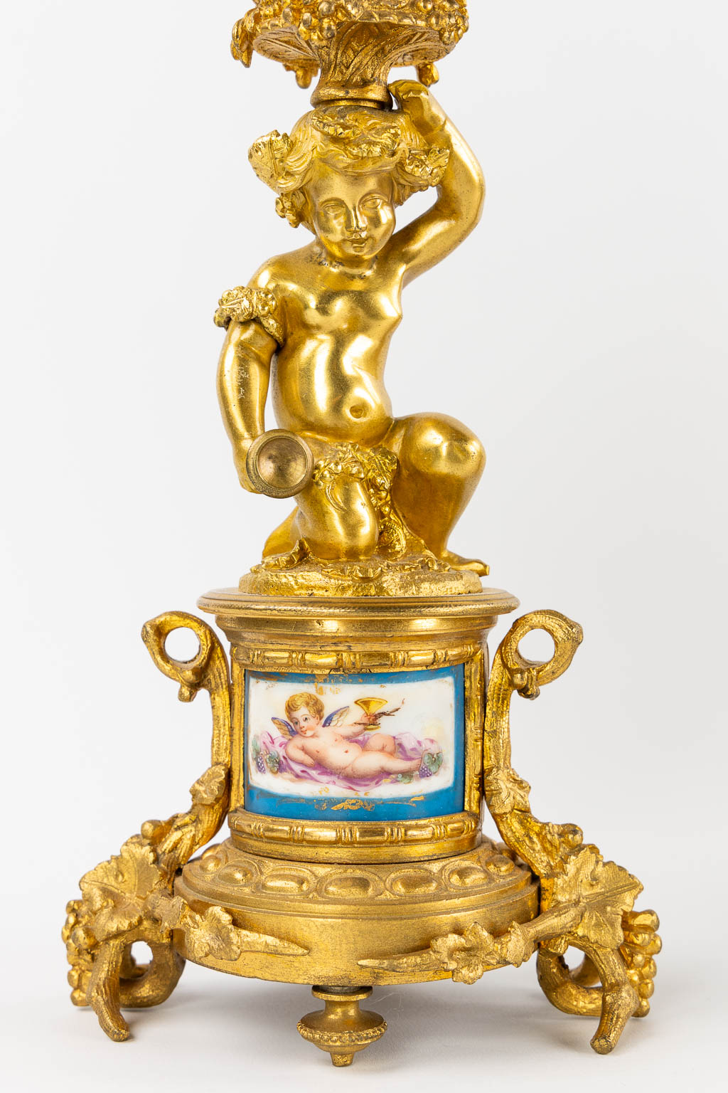 A three-piece mantle garniture clock and candelabra, gilt bronze and Sèvres porcelain, 19th C. (L:20 x W:53 x H:52 cm)