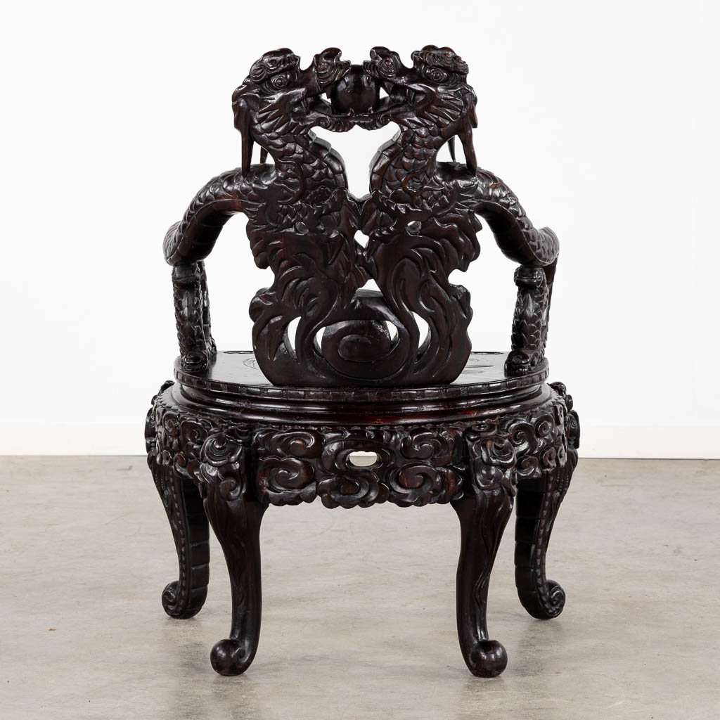 A Chinese sculptured hardwood armchair with a dragon decor. 