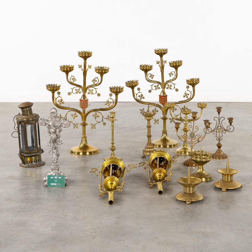 A large collection of church candelabra, lights and a crucifix, brass. (W:46 x H:61 cm)