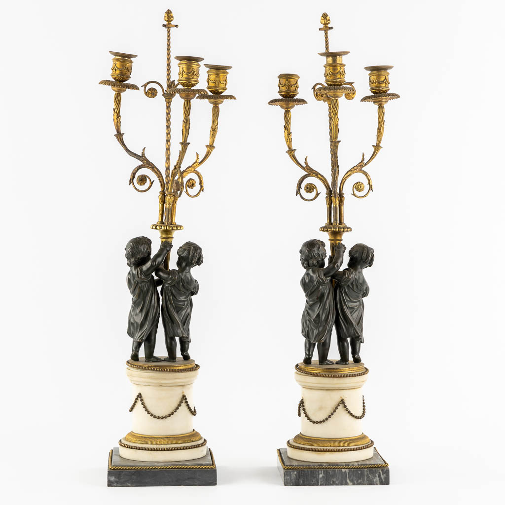 A pair of Marble, gilt and patinated bronze candelabra with putti, Louis XVI style, 19th C. (L:16,5 x W:16,5 x H:71,5 cm)