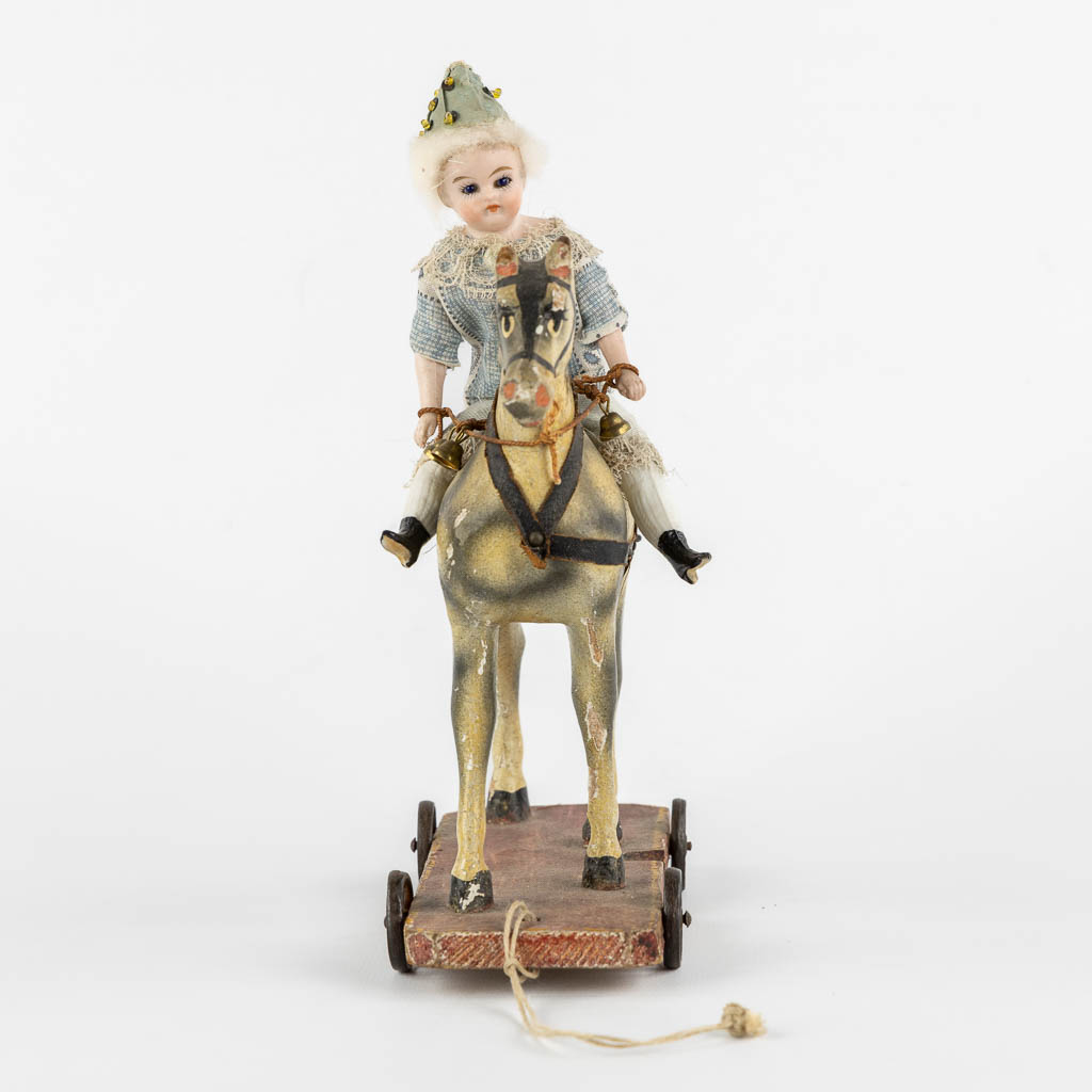 Kinderspeelgoed, een figuur van een Mignonette op een paard, bijgevoegd een Lama. (H:22 cm)