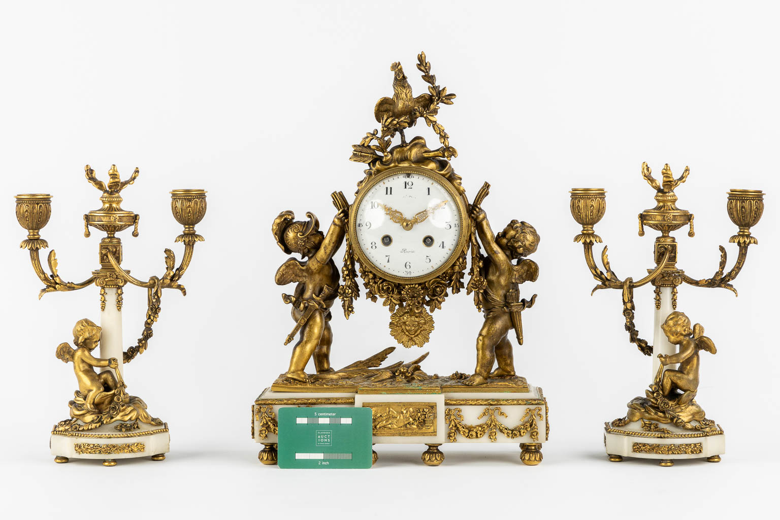 A three-piece mantle garniture clock and candelabra, bronze and marble, 19th C. (L:11 x W:27 x H:36 cm)