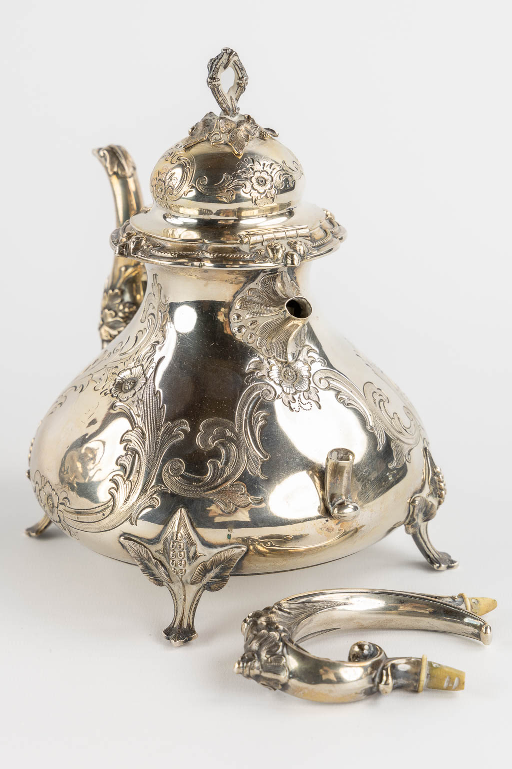 Een verzilverd koffie en theeservies met samovar, suikerpot, melkkan en tafelbel. H&Co. (L:20 x W:26 x H:44 cm)