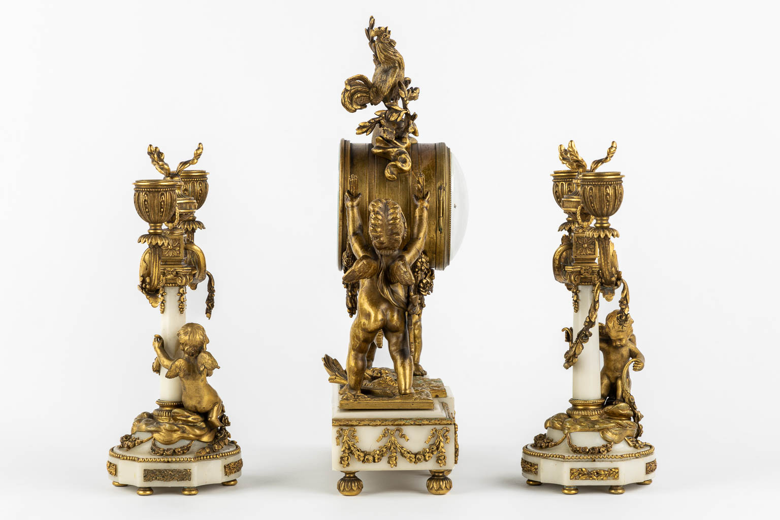 A three-piece mantle garniture clock and candelabra, bronze and marble, 19th C. (L:11 x W:27 x H:36 cm)