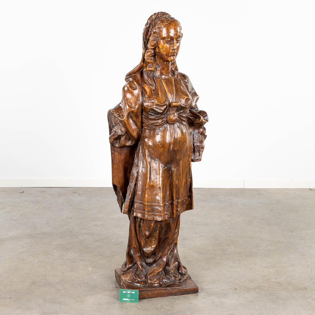 Een antieke houtsculptuur, figuur van een edeldame. 17de/18de eeuw. (L:30 x W:53 x H:123 cm)