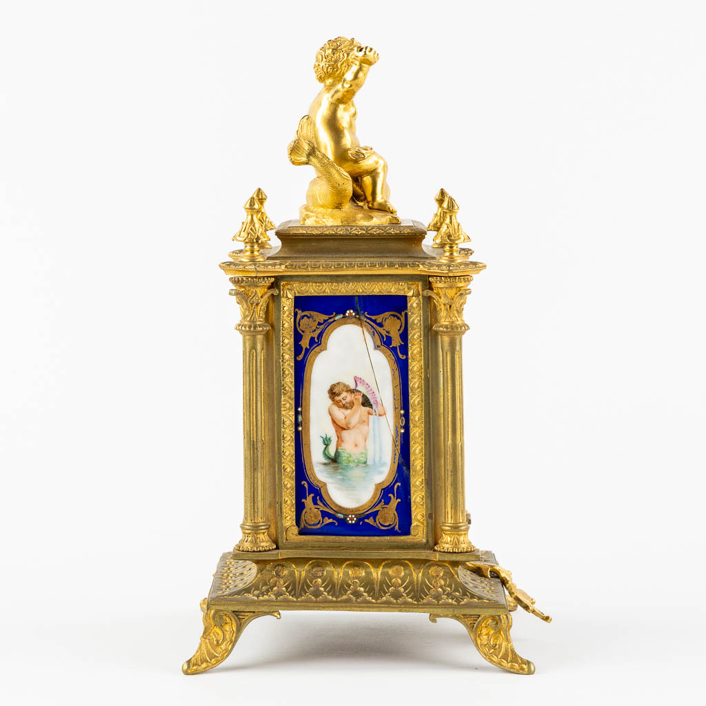 A mantle clock, gilt bronze mounted with porcelain. 19th C.