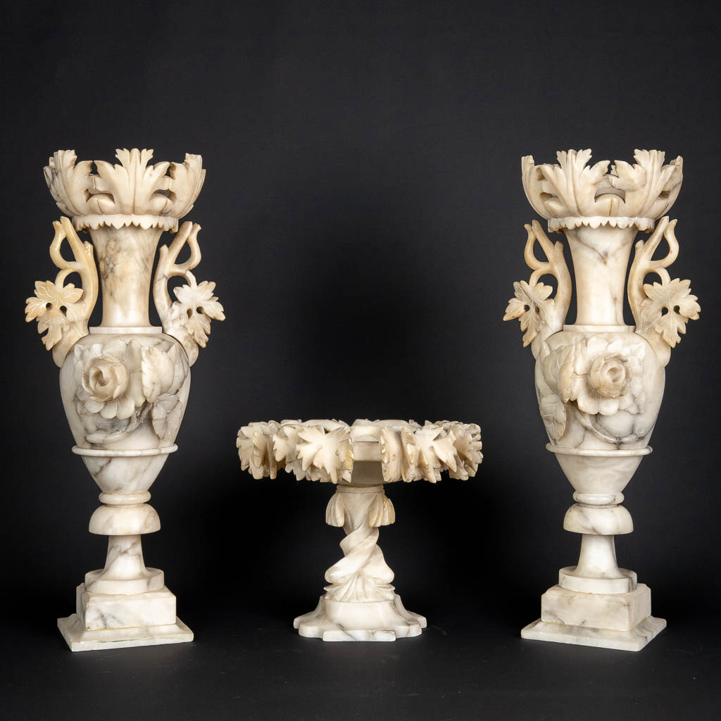 A three piece mantle garniture set, sculptured alabaster. (H:45 x D:15 cm)