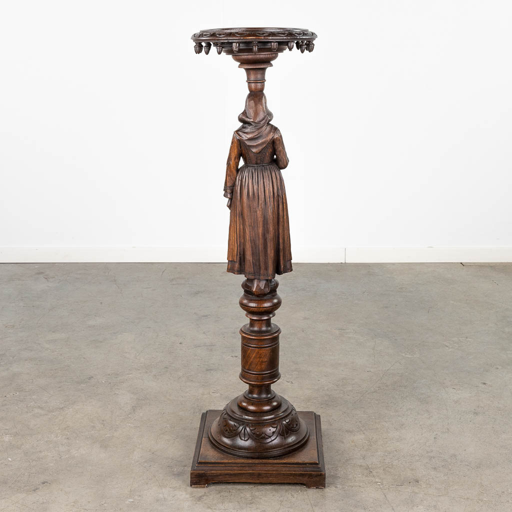 A pedestal with a wood sculptured figurine in Breton style. Circa 1900. (L: 31,5 x W: 31,5 x H: 107 cm)