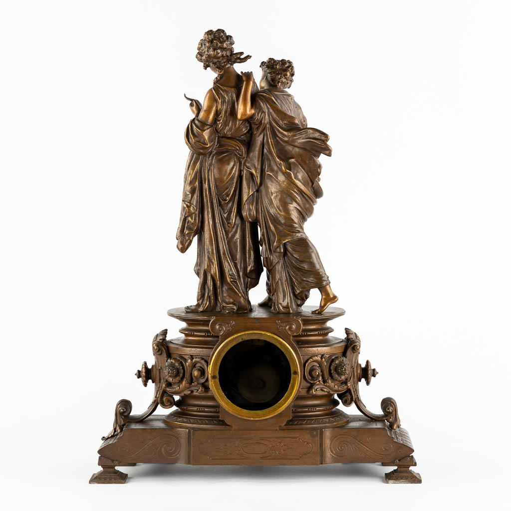 A large mantle clock with two ladies, patinated spelter. Circa 1900. (L:18 x W:42 x H:58 cm)