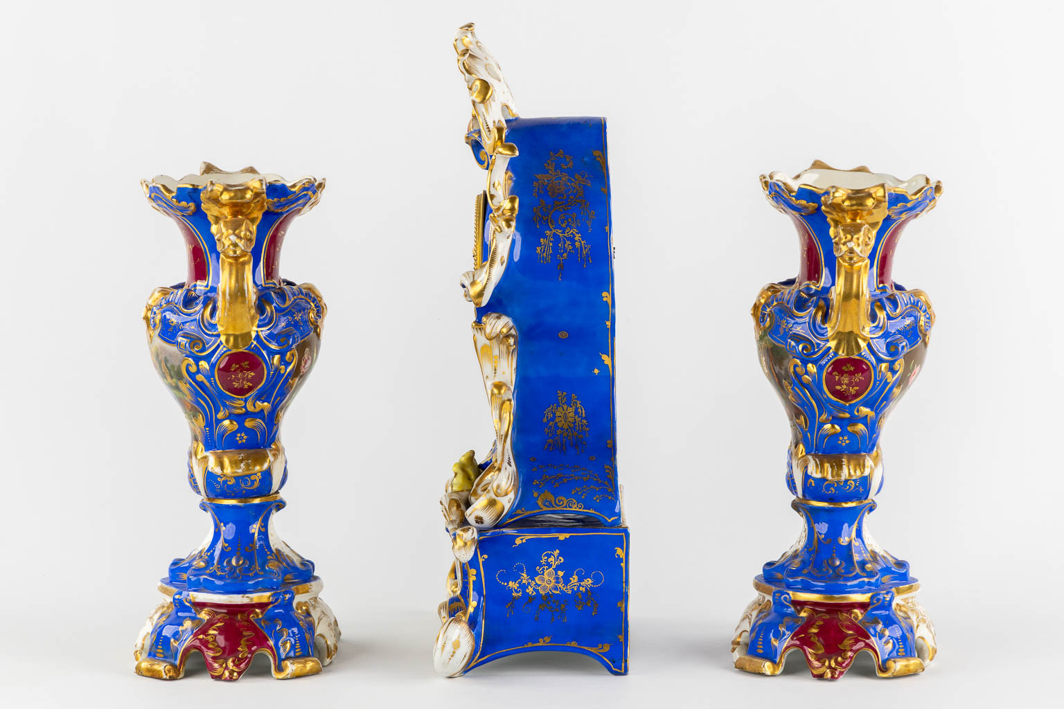 A Vieux Paris mantle clock with two side pieces, in the style of Jacob Petit. 19th C. (L:13 x W:25 x H:41 cm)