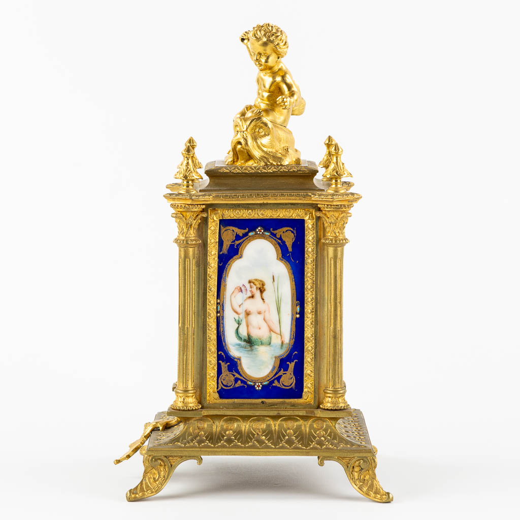 A mantle clock, gilt bronze mounted with porcelain. 19th C.