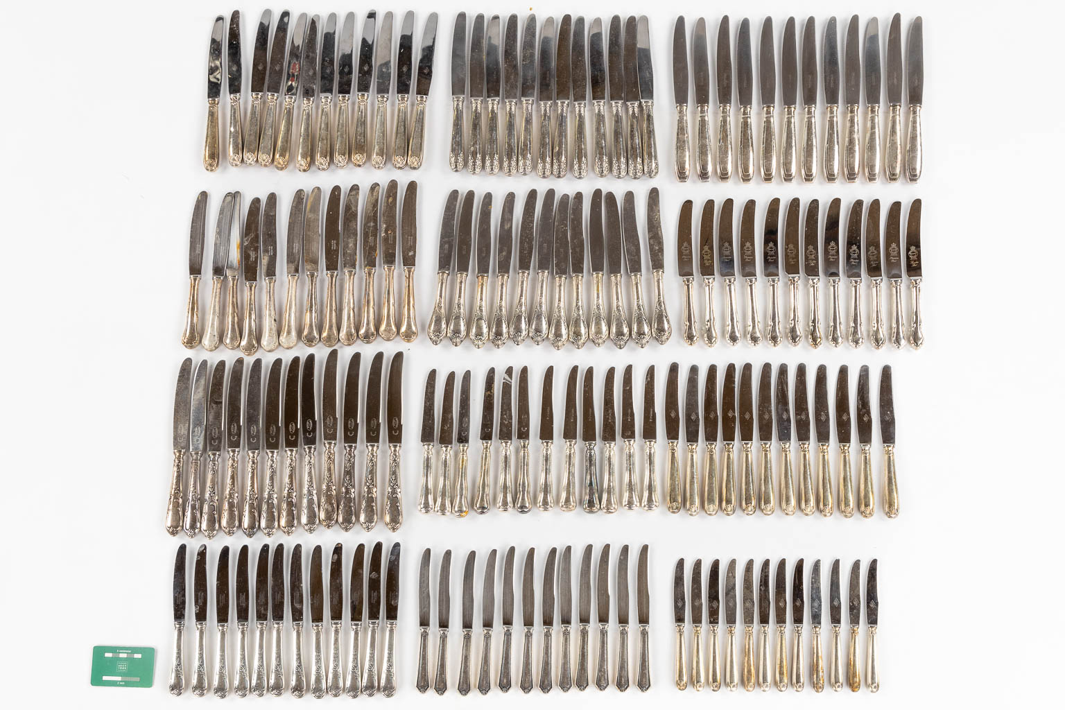 Twelve sets of twelve silver-plated knives. 