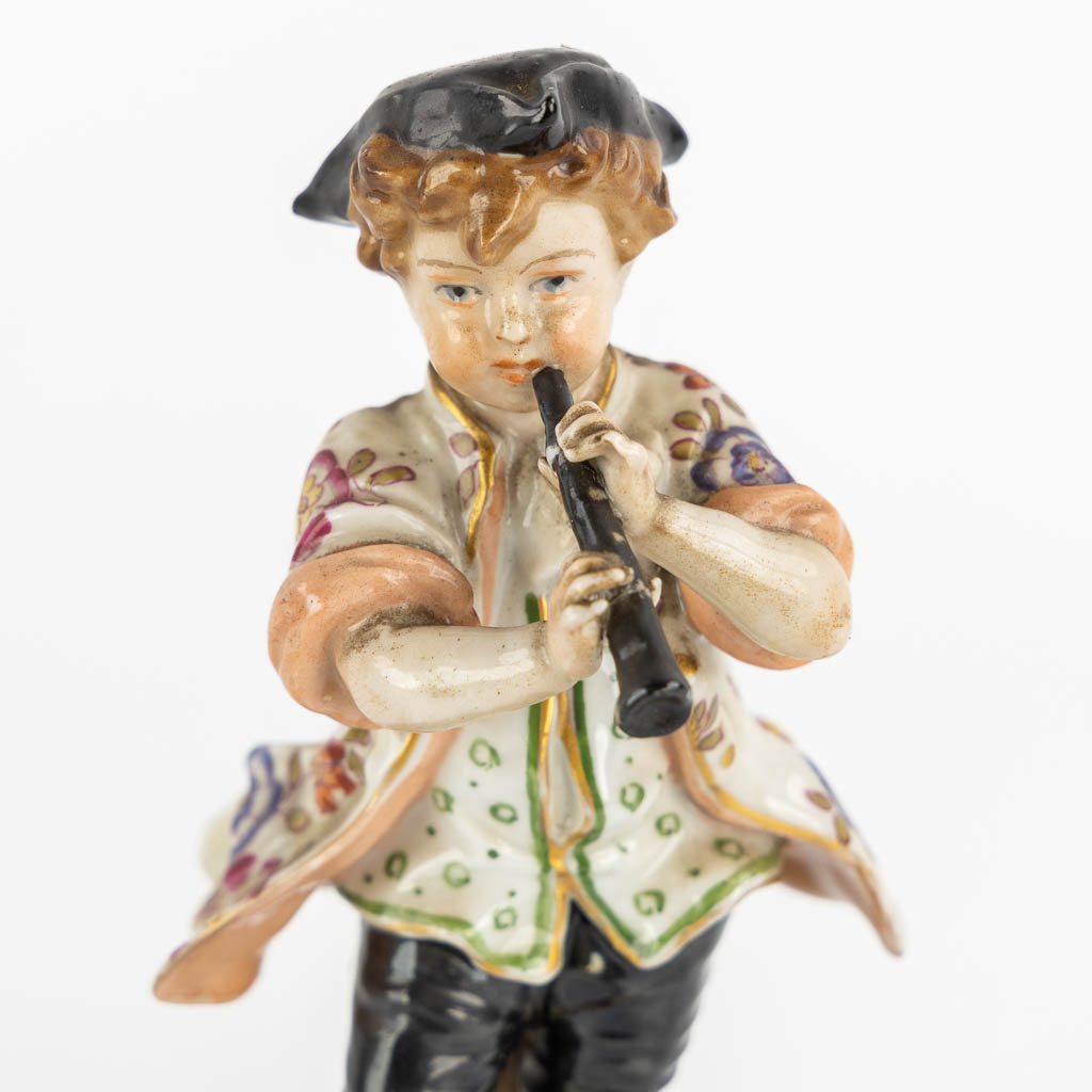 A pair of polychrome porcelain figurines, added A Saxony porcelain boy. (H:23,5 cm)