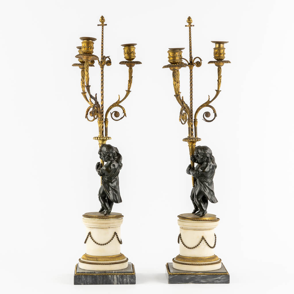 A pair of Marble, gilt and patinated bronze candelabra with putti, Louis XVI style, 19th C. (L:16,5 x W:16,5 x H:71,5 cm)