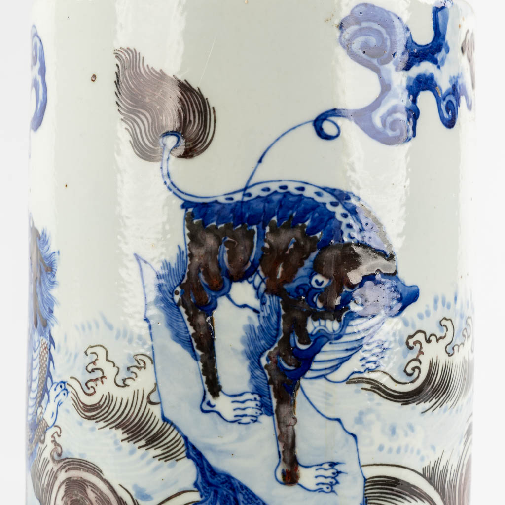 A Chinese Rouleau vase with a blue, black and white Foo Dog. Kangxi mark, 19th C. (H:39 x D:29 cm)