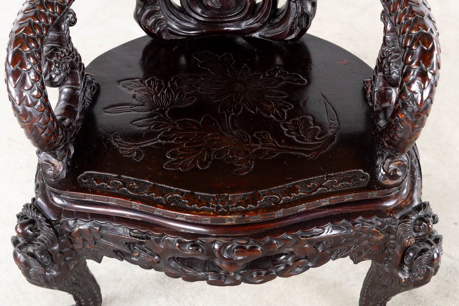 A Chinese sculptured hardwood armchair with a dragon decor. 