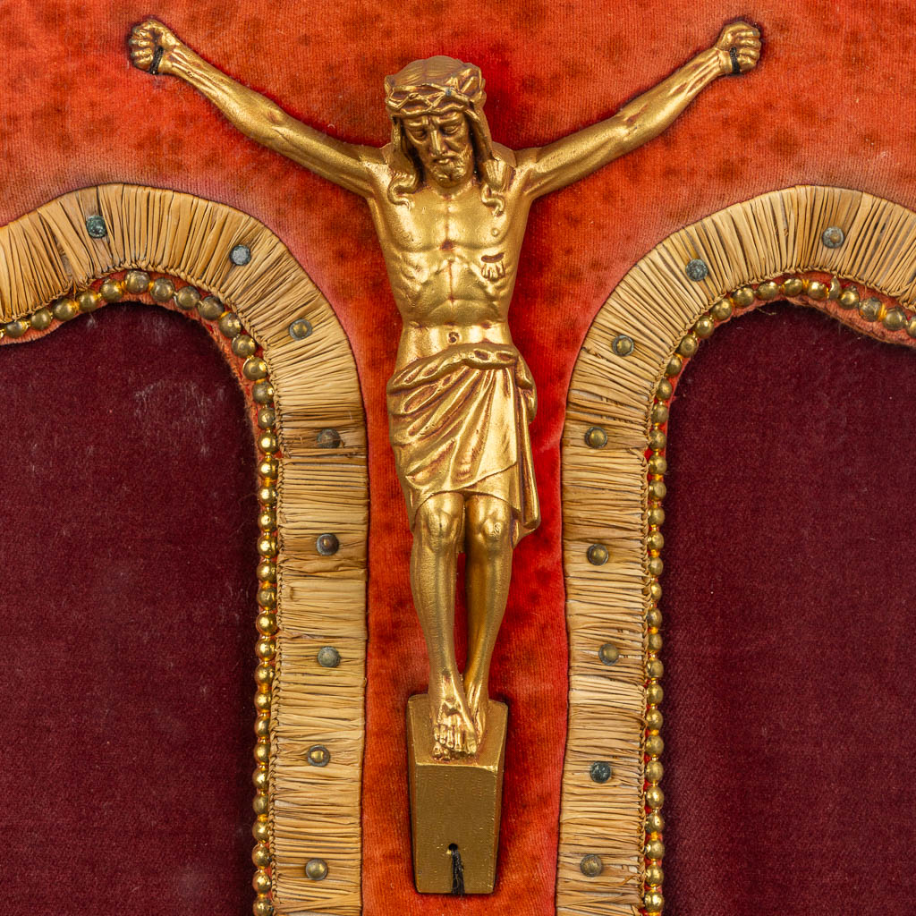 A framed embroidered crucifix with a Corpus Christi, framed behind glass. 