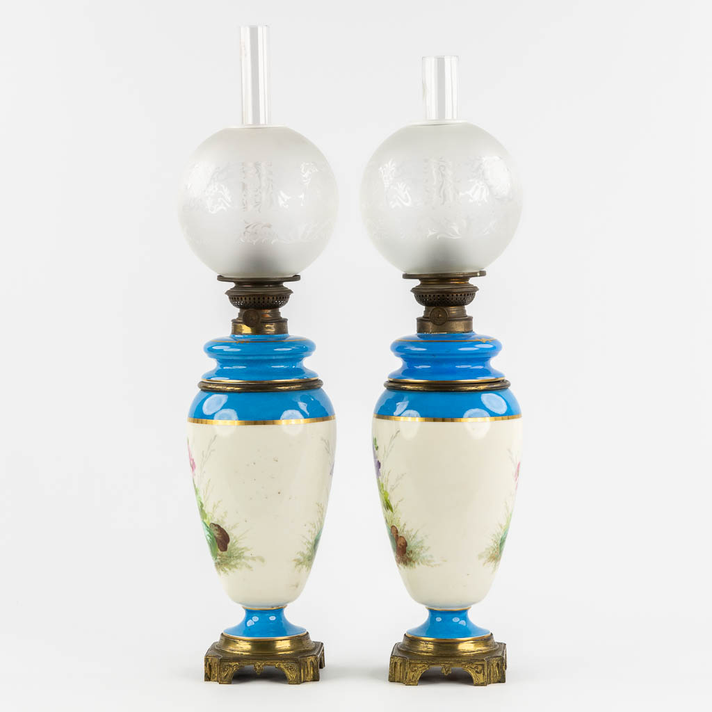 A pair of oil lamps, hand-painted porcelain. 19th C. (H:69 cm)